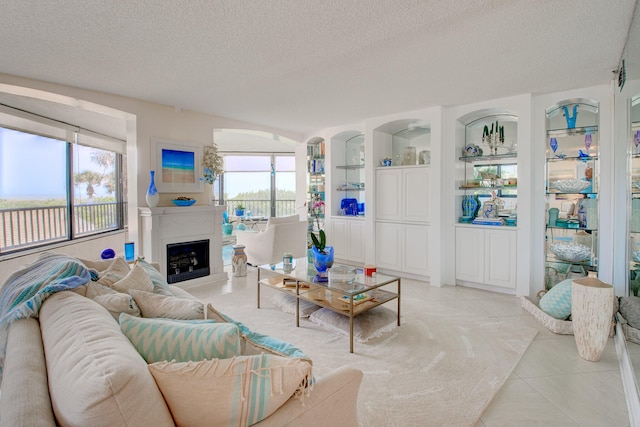 tiled living room featuring built in shelves and a textured ceiling