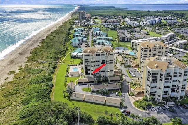 drone / aerial view featuring a beach view and a water view