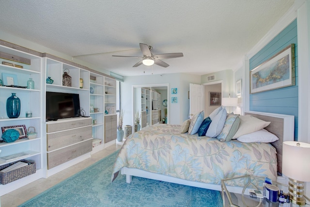 bedroom with ceiling fan and a textured ceiling