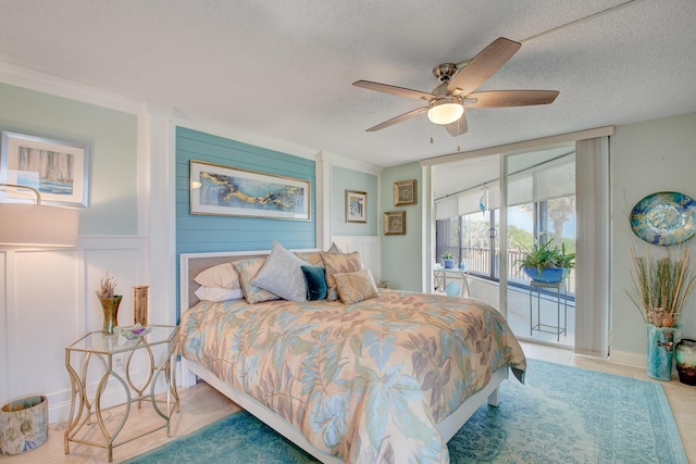 bedroom featuring ceiling fan, access to exterior, and a textured ceiling