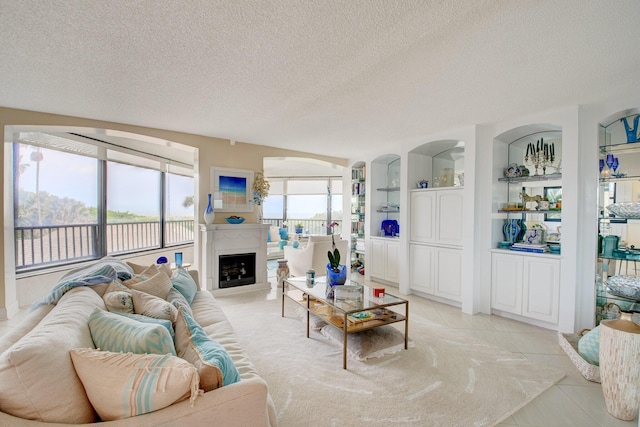 tiled living room with built in features and a textured ceiling