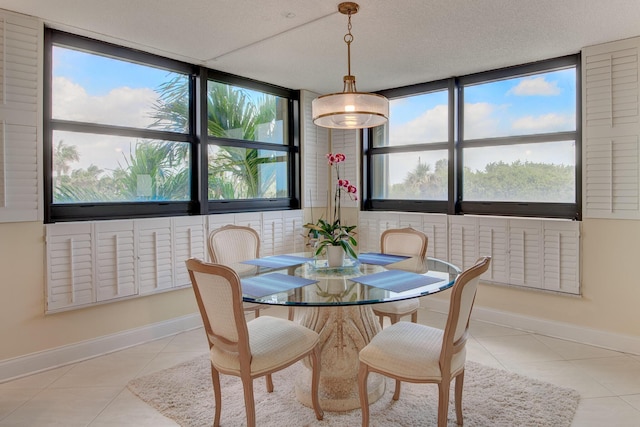 tiled dining space featuring a textured ceiling