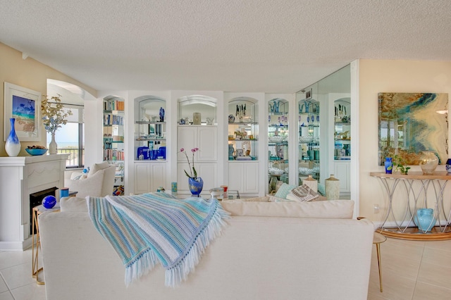 living room featuring built in features, a textured ceiling, and light tile patterned floors