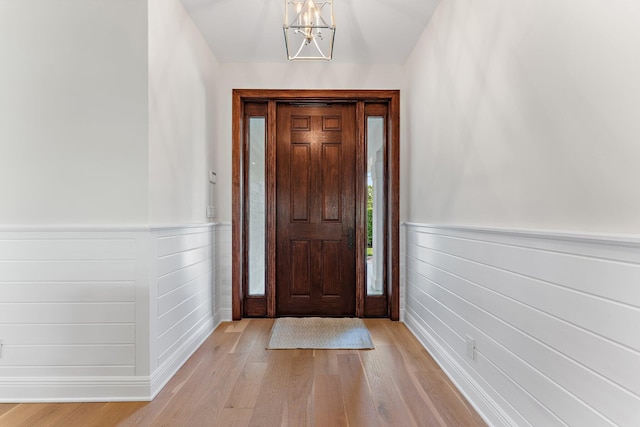 foyer with light hardwood / wood-style floors and an inviting chandelier