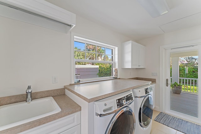 clothes washing area featuring washer and dryer, light tile patterned floors, cabinets, and sink