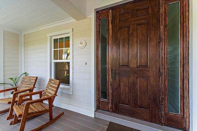 view of exterior entry featuring covered porch