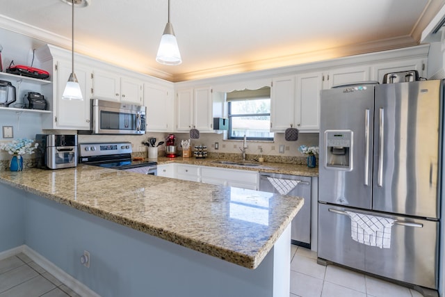 kitchen with appliances with stainless steel finishes, sink, kitchen peninsula, hanging light fixtures, and white cabinetry