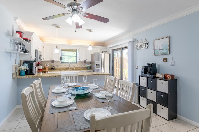 dining space with crown molding, ceiling fan, light tile patterned flooring, and a wealth of natural light