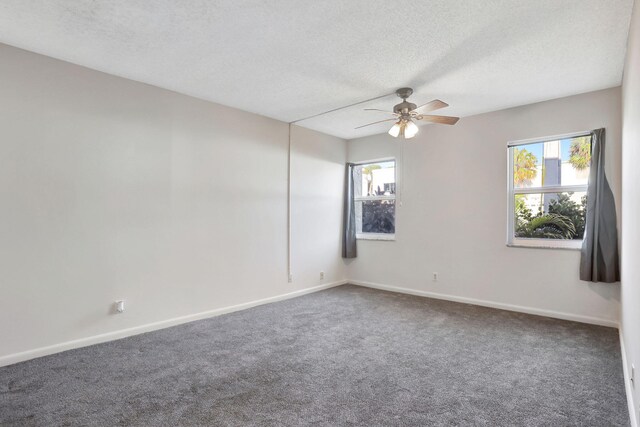 carpeted spare room with ceiling fan, a textured ceiling, and baseboards