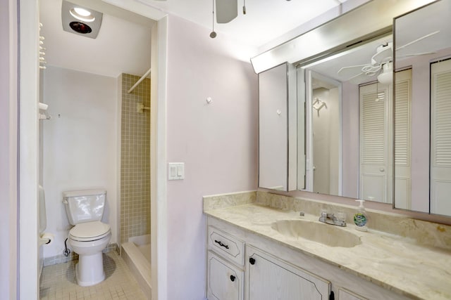 bathroom with a ceiling fan, toilet, vanity, a shower stall, and a closet