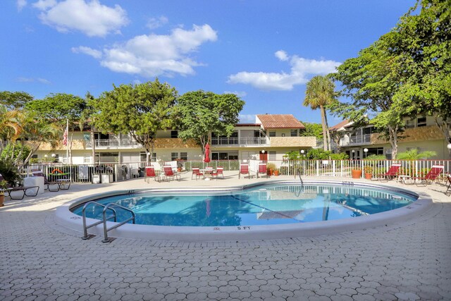 community pool featuring a patio and fence