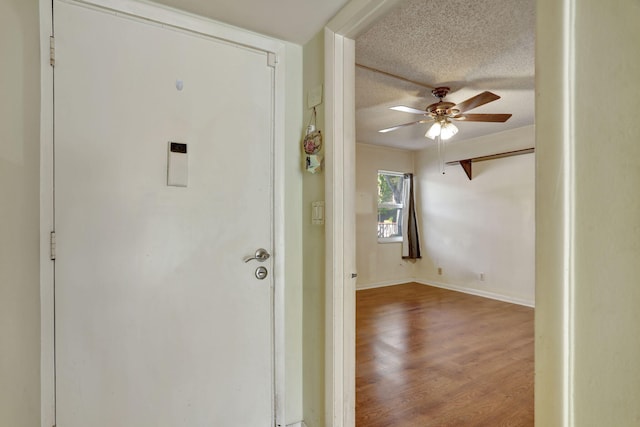 interior space with a textured ceiling, hardwood / wood-style flooring, and ceiling fan