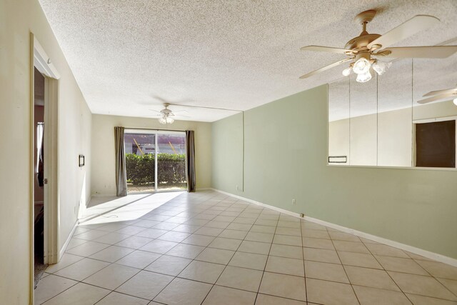 tiled empty room featuring a textured ceiling and ceiling fan