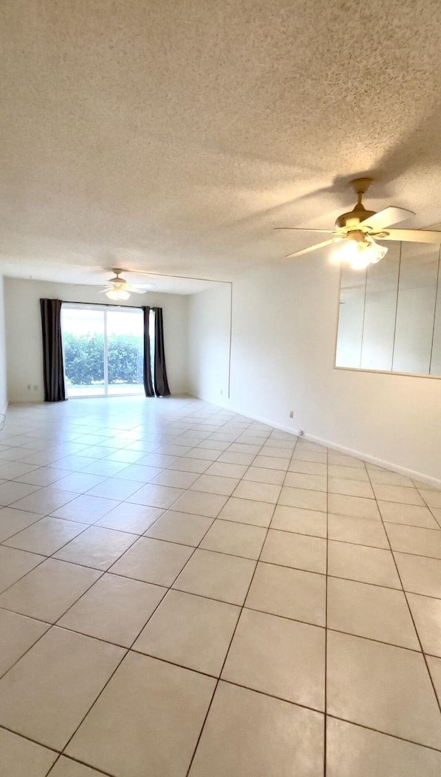 spare room with light tile patterned floors, a textured ceiling, and a ceiling fan