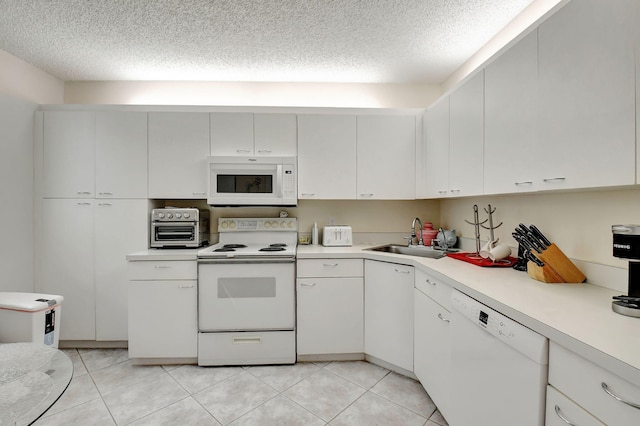 kitchen featuring sink, white cabinets, white appliances, and light tile patterned floors