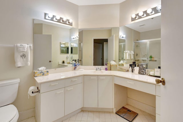 bathroom featuring tile patterned flooring, vanity, toilet, and a shower with shower door