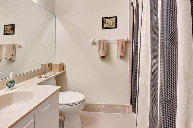 bathroom with tile patterned flooring, vanity, and toilet