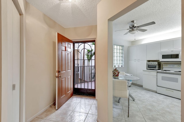 tiled entryway featuring ceiling fan and a textured ceiling