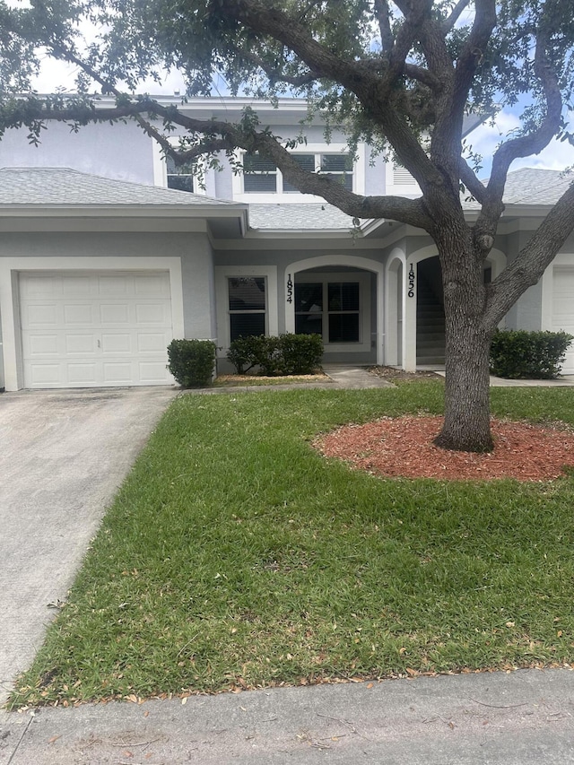 1854 Sandhill Crane Dr Unit 2, Fort Pierce, FL 34982 - view of front of house with a front lawn, driveway, a shingled roof, and an attached garage