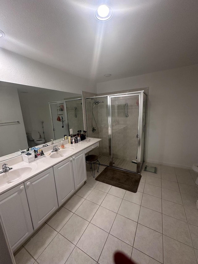 bathroom with tile patterned flooring, vanity, an enclosed shower, and toilet