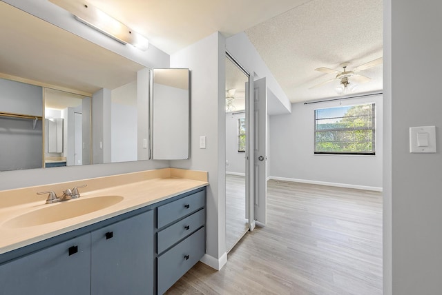 bathroom featuring vanity, a textured ceiling, hardwood / wood-style flooring, and ceiling fan