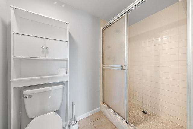 bathroom featuring toilet, tile patterned floors, and a shower with door