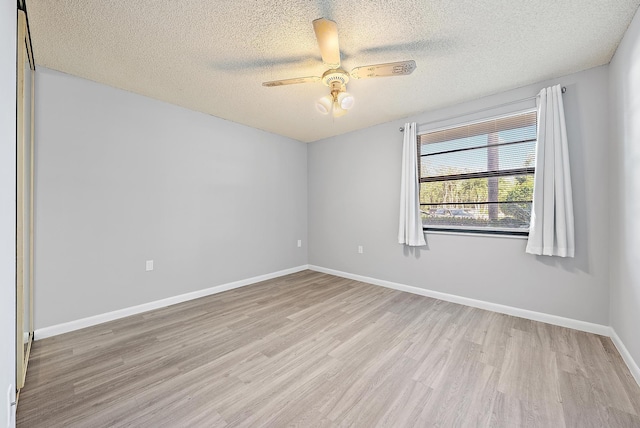 empty room featuring light hardwood / wood-style floors, a textured ceiling, and ceiling fan