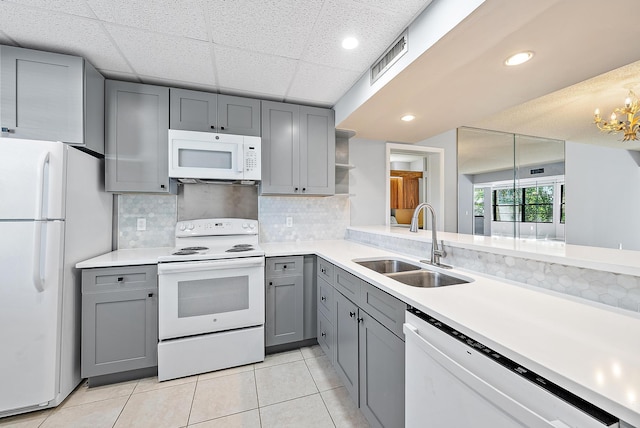 kitchen featuring gray cabinetry, sink, pendant lighting, and white appliances