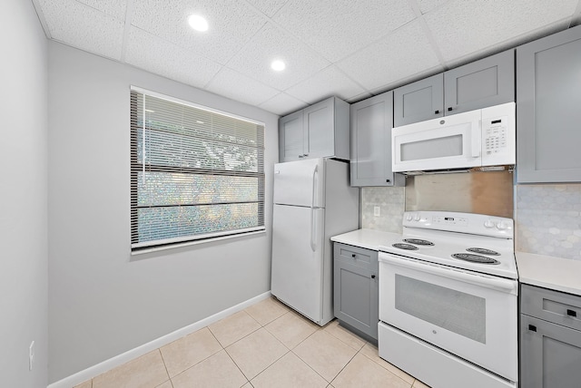 kitchen with white appliances, tasteful backsplash, light tile patterned floors, and gray cabinetry