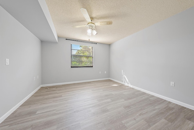 empty room with a textured ceiling, light hardwood / wood-style floors, and ceiling fan