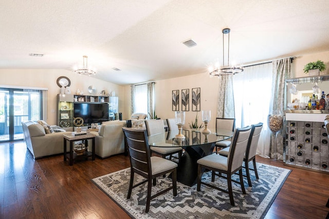 dining room featuring a chandelier, vaulted ceiling, and dark hardwood / wood-style flooring