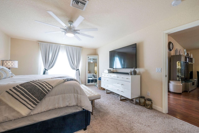 bedroom featuring a textured ceiling, wood-type flooring, and ceiling fan