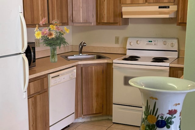 kitchen featuring light tile patterned flooring, sink, and white appliances