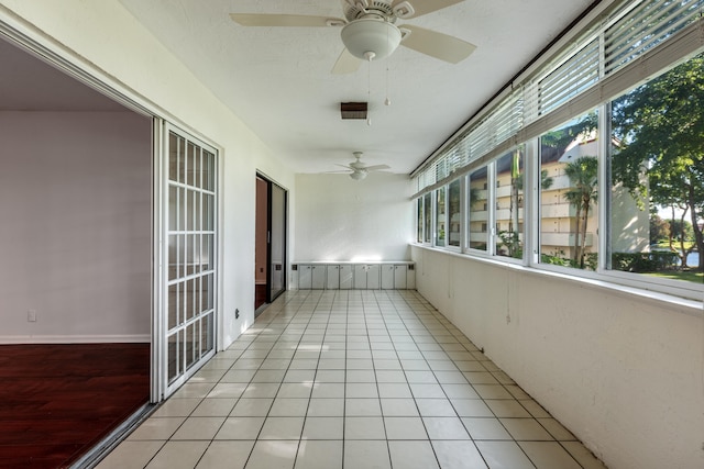 unfurnished sunroom with ceiling fan