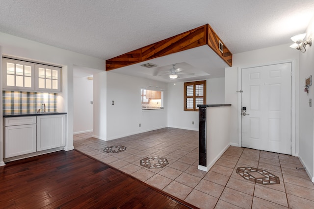 entryway with ceiling fan, light hardwood / wood-style flooring, a textured ceiling, and sink