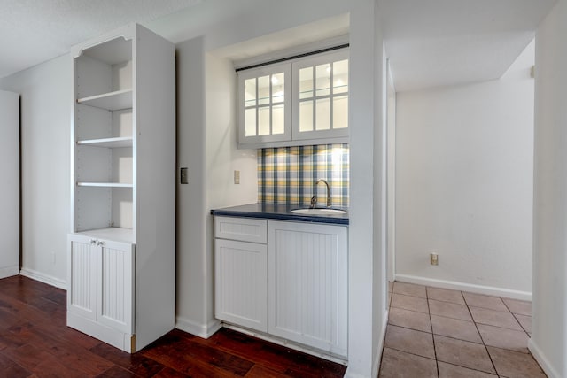 interior space with hardwood / wood-style flooring, white cabinetry, and sink