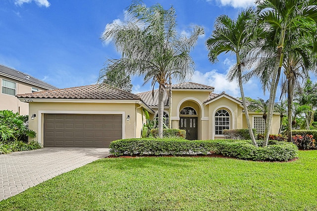 mediterranean / spanish house with a front lawn and a garage