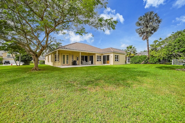 back of property featuring a patio area and a lawn