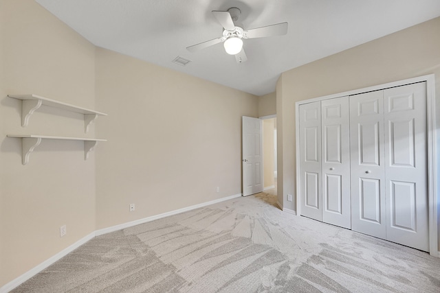 unfurnished bedroom featuring a closet, light colored carpet, and ceiling fan