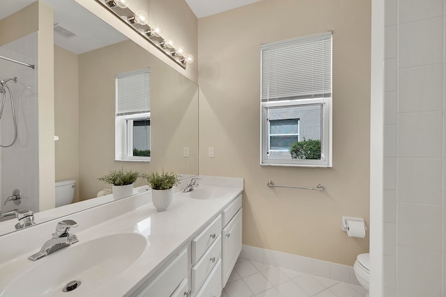 bathroom with vanity, toilet, tile patterned floors, and walk in shower