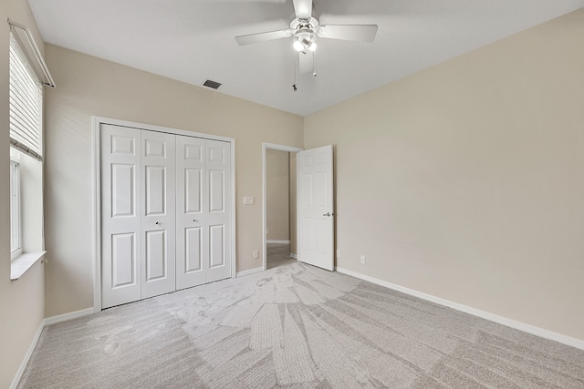 unfurnished bedroom with light carpet, a closet, and ceiling fan