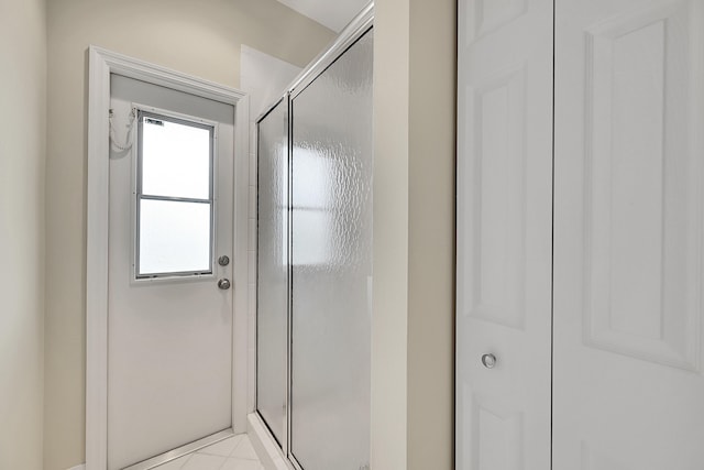 bathroom with tile patterned flooring and an enclosed shower