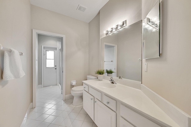 bathroom with toilet, vanity, and tile patterned floors