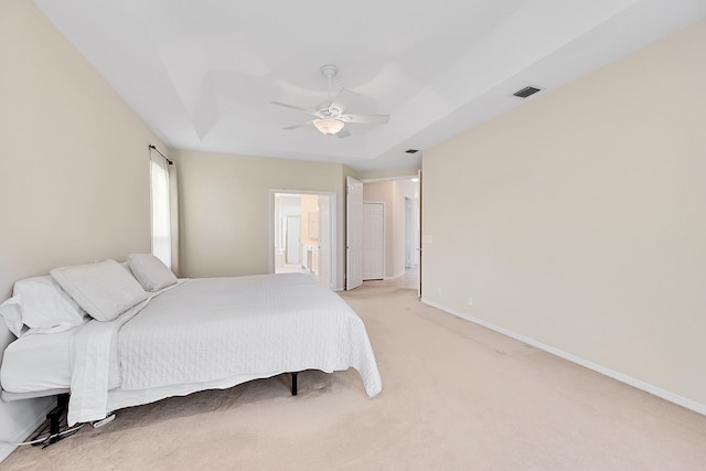 bedroom with connected bathroom, ceiling fan, and light carpet