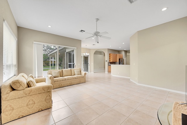 living room featuring light tile patterned floors and ceiling fan with notable chandelier