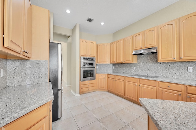 kitchen with light brown cabinetry, light stone countertops, and backsplash