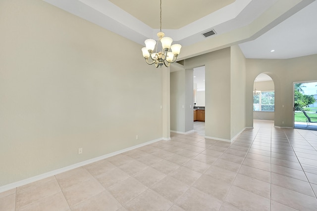 empty room featuring light tile patterned flooring and an inviting chandelier