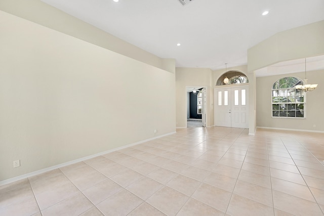 tiled empty room featuring a notable chandelier