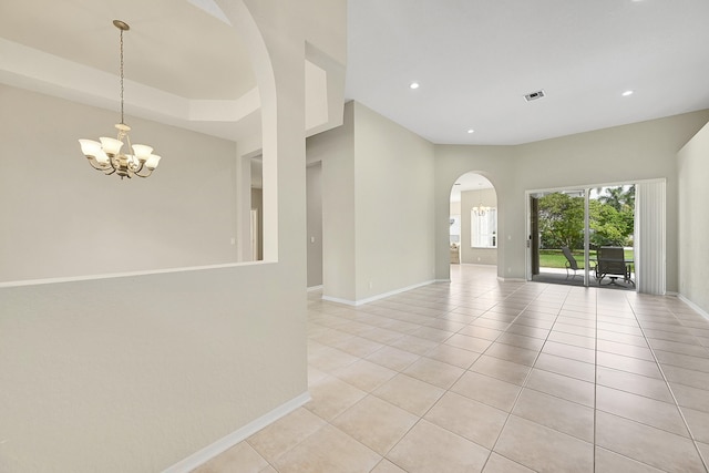 tiled empty room with a chandelier