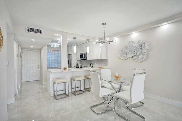 dining area with sink and a notable chandelier